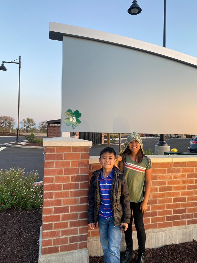 young boy and girl in front of brick wall at River Islands in Lathrop