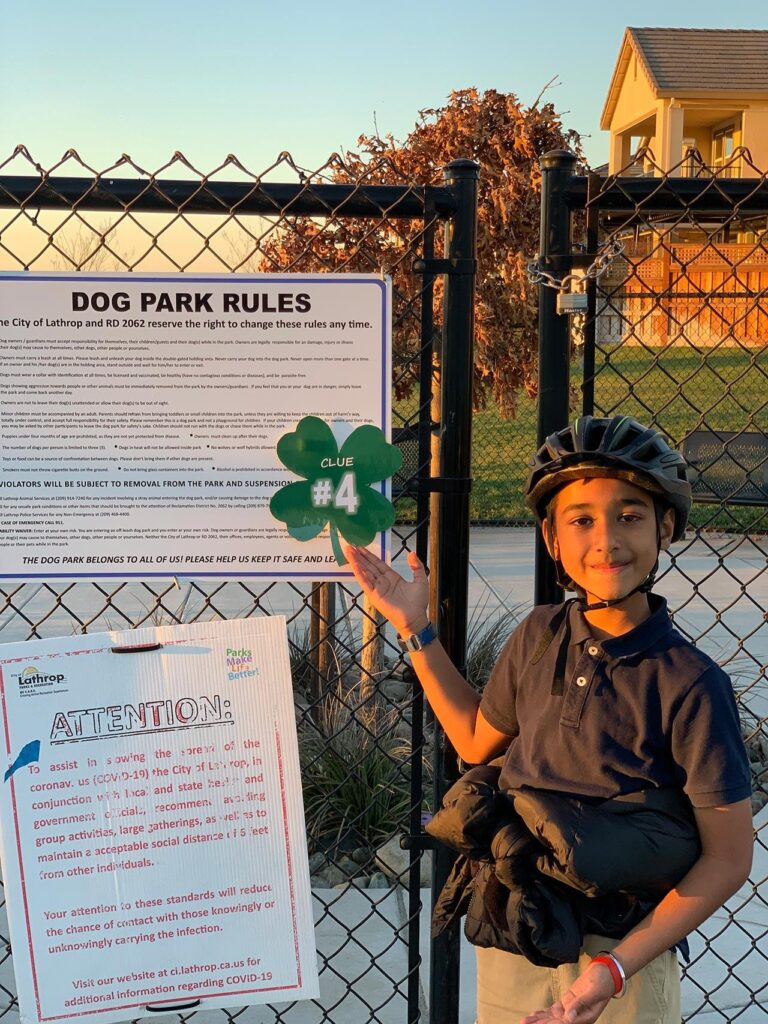 young boy in front of sign on gate at River Islands in Lathrop
