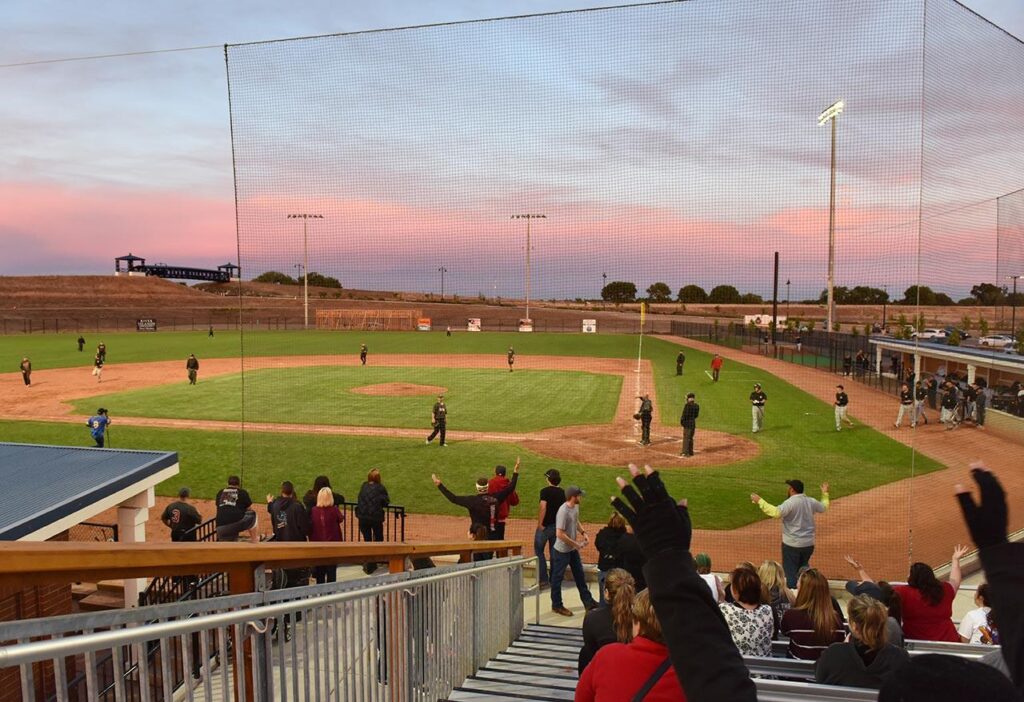 crowd cheering on a baseball game at Islanders Field at sunset