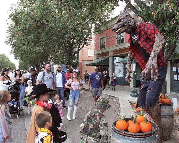 kids gather around a werewolf at the Tracy Annual Halloween Haunt