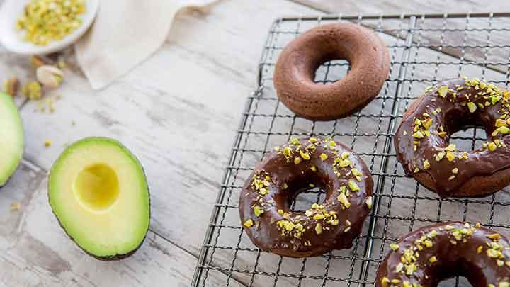 donuts and avocadoes on a white counter