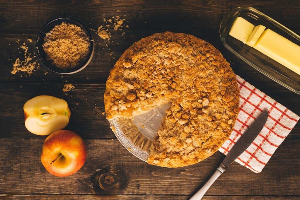 an apple crumble pie with a piece missing