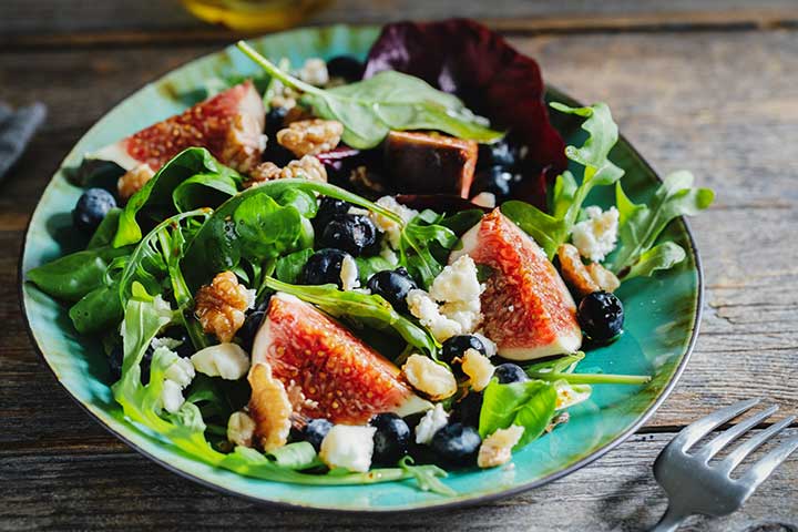 fig and arugala salad in blue bowl