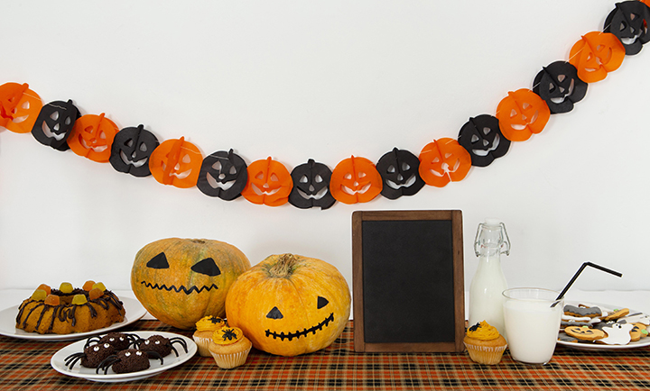 table with halloween banner pumpkins and snacks
